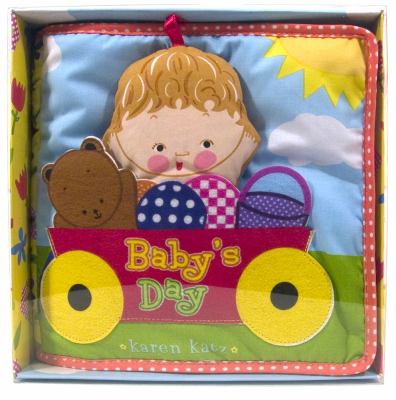 Baby's Day cloth book jaket of a artoon baby's large head and a teddy bear in a red wagon with yellow wheels.