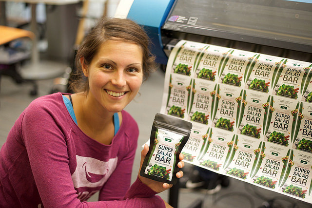 Photograph of Renee Volchko with a display of her product Super Salad Bar