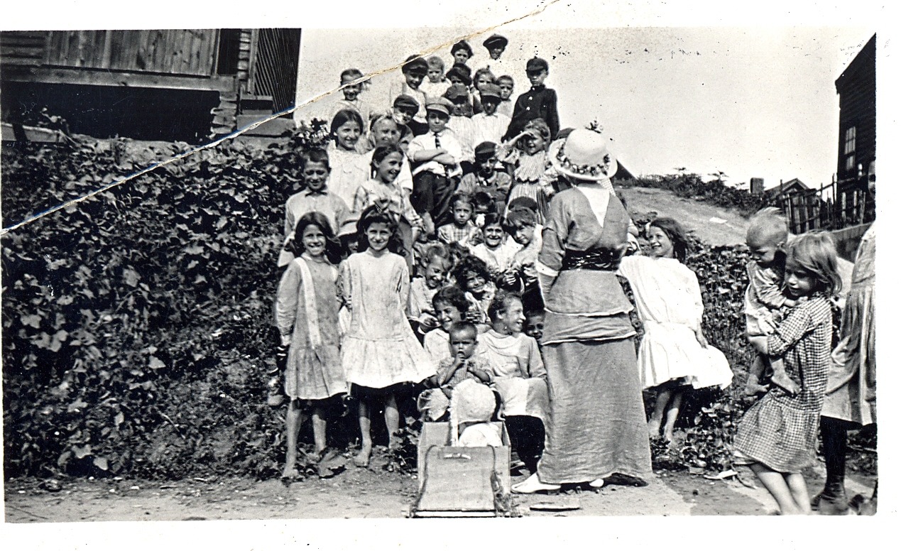 Group of children standing on a hill for open-air story hour from around 1910.