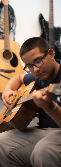 Joswen Colon playing guitar in South Branch’s sound booth