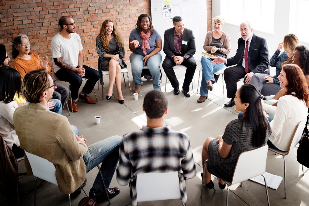 Community members sitting in a circle while having a group discussion